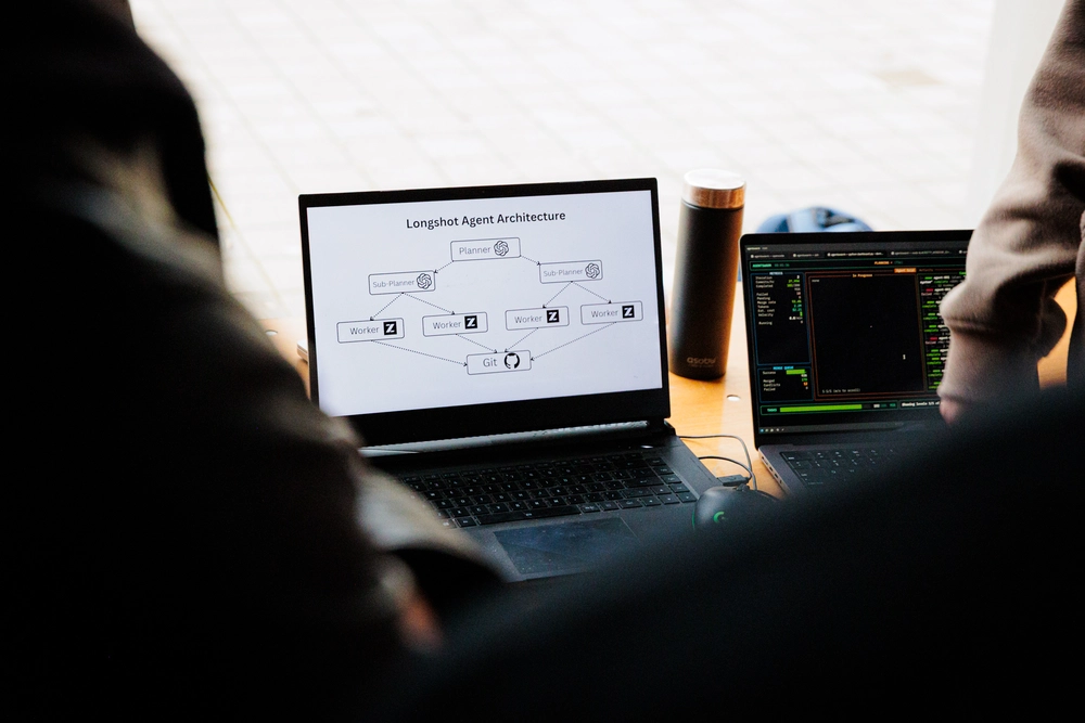 Laptop displaying a Longshot Agent Architecture diagram with planner and worker nodes at TreeHacks