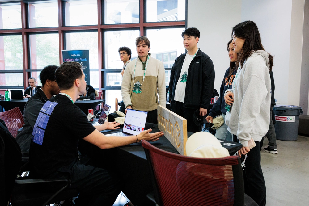 Students gather around a table to chat at the TreeHacks hackathon