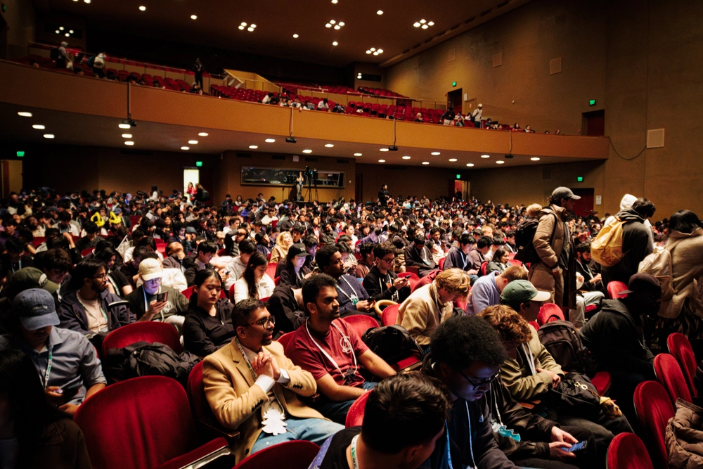 Crowd of attendees fills an auditorium at the TreeHacks hackathon
