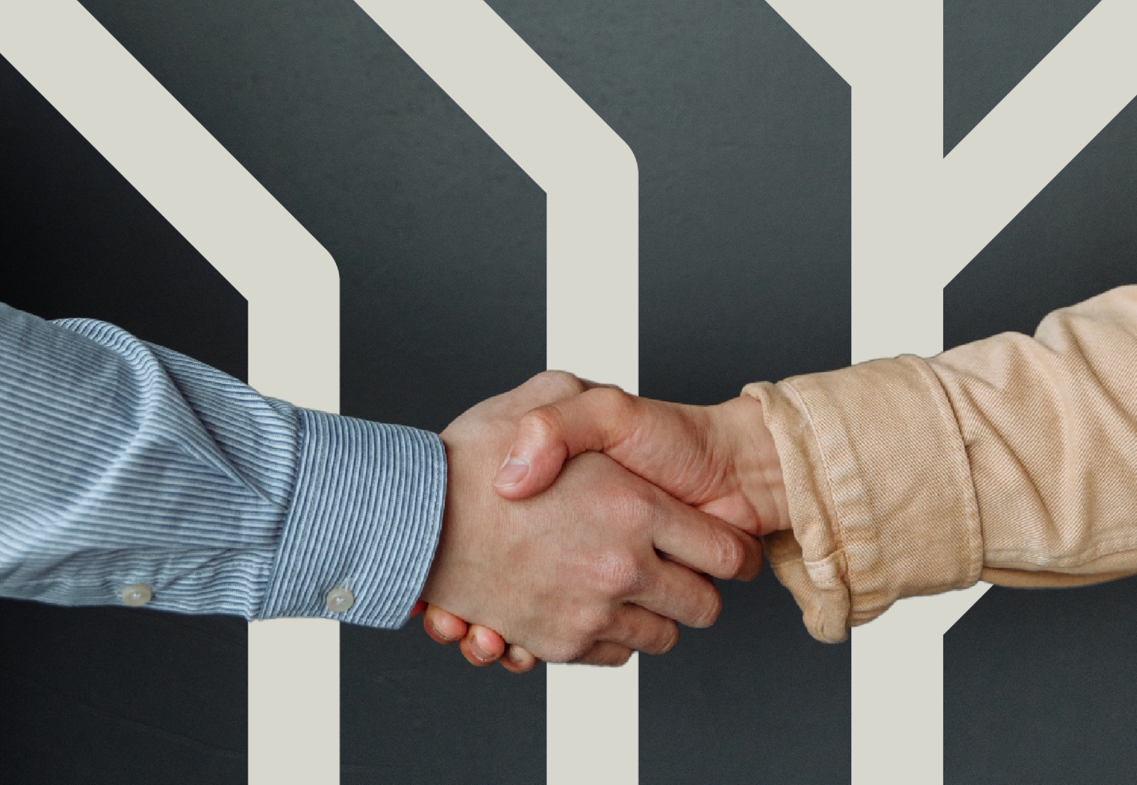 Two people shaking hands in front of a large geometric V shape