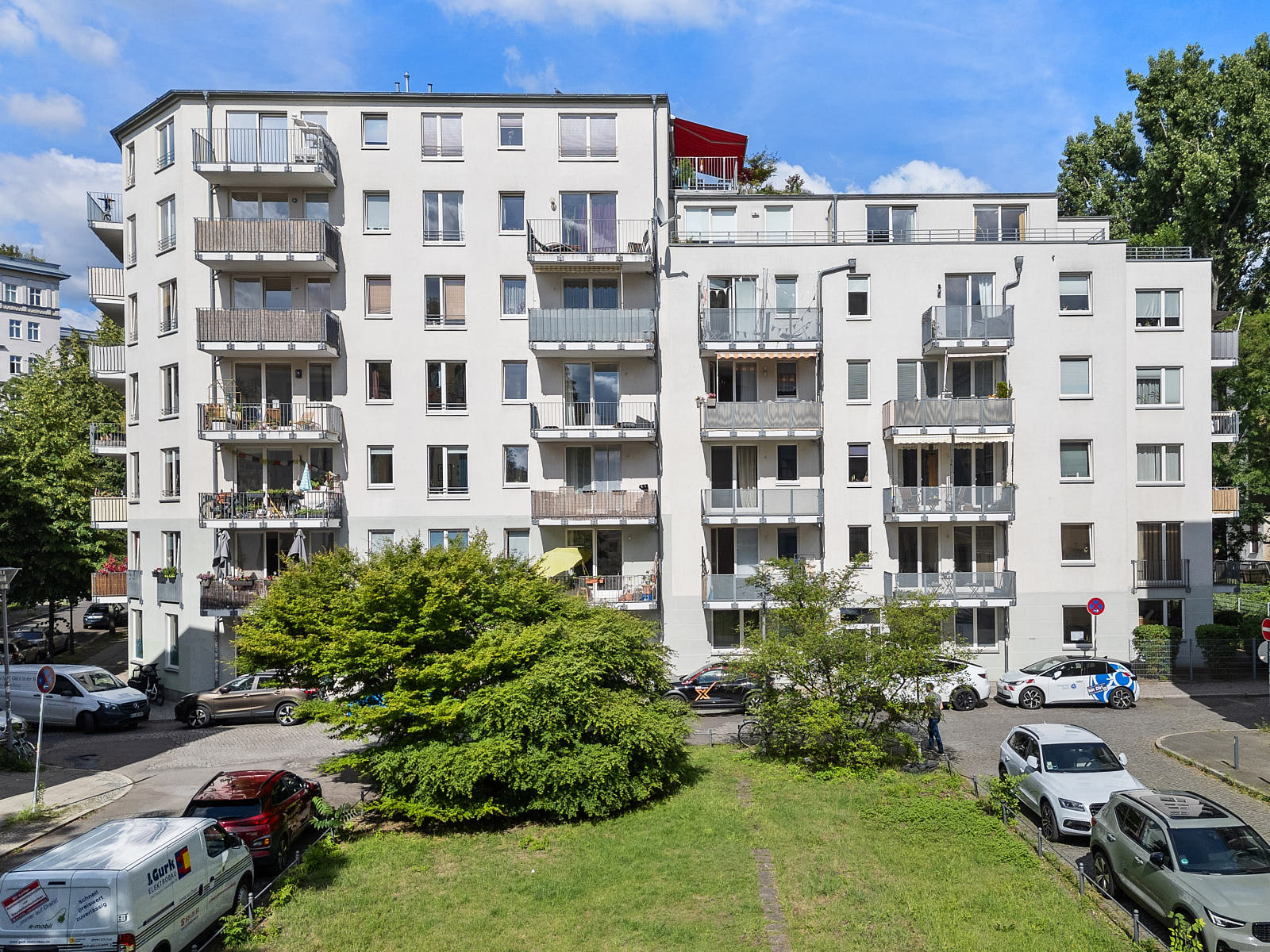 Mehrfamilienhaus in Berlin mit heller Fassade, Balkonen und begrüntem Vorgarten
