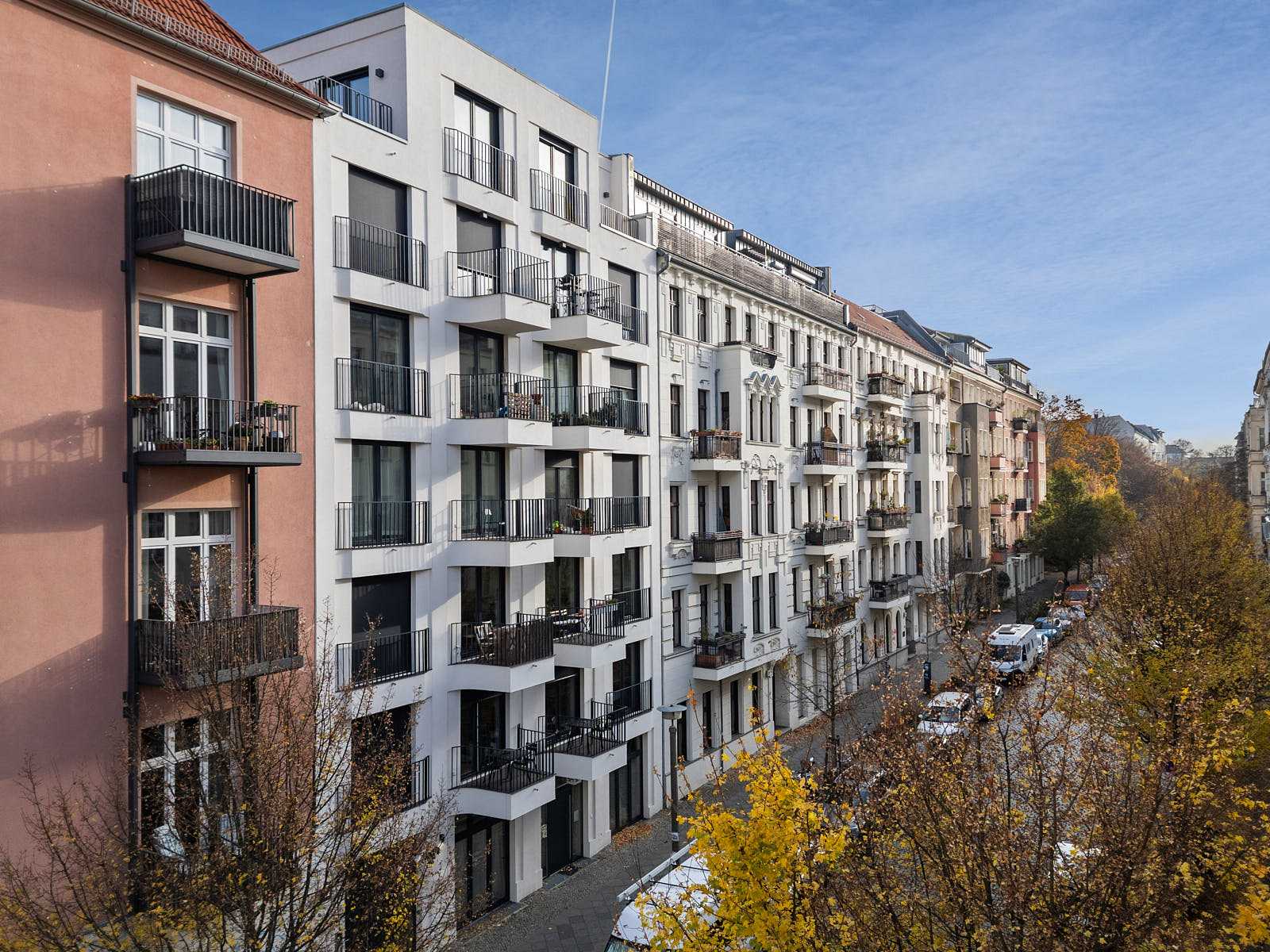 Berliner Wohnstraße mit sanierten Altbauten, modernem Neubau und Balkonen