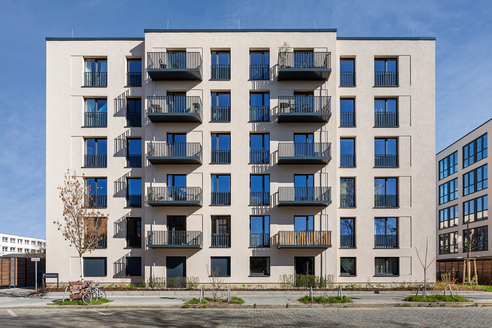 Modernes Mehrfamilienhaus in Berlin mit heller Fassade, Balkonen und klar gegliederter Frontansicht