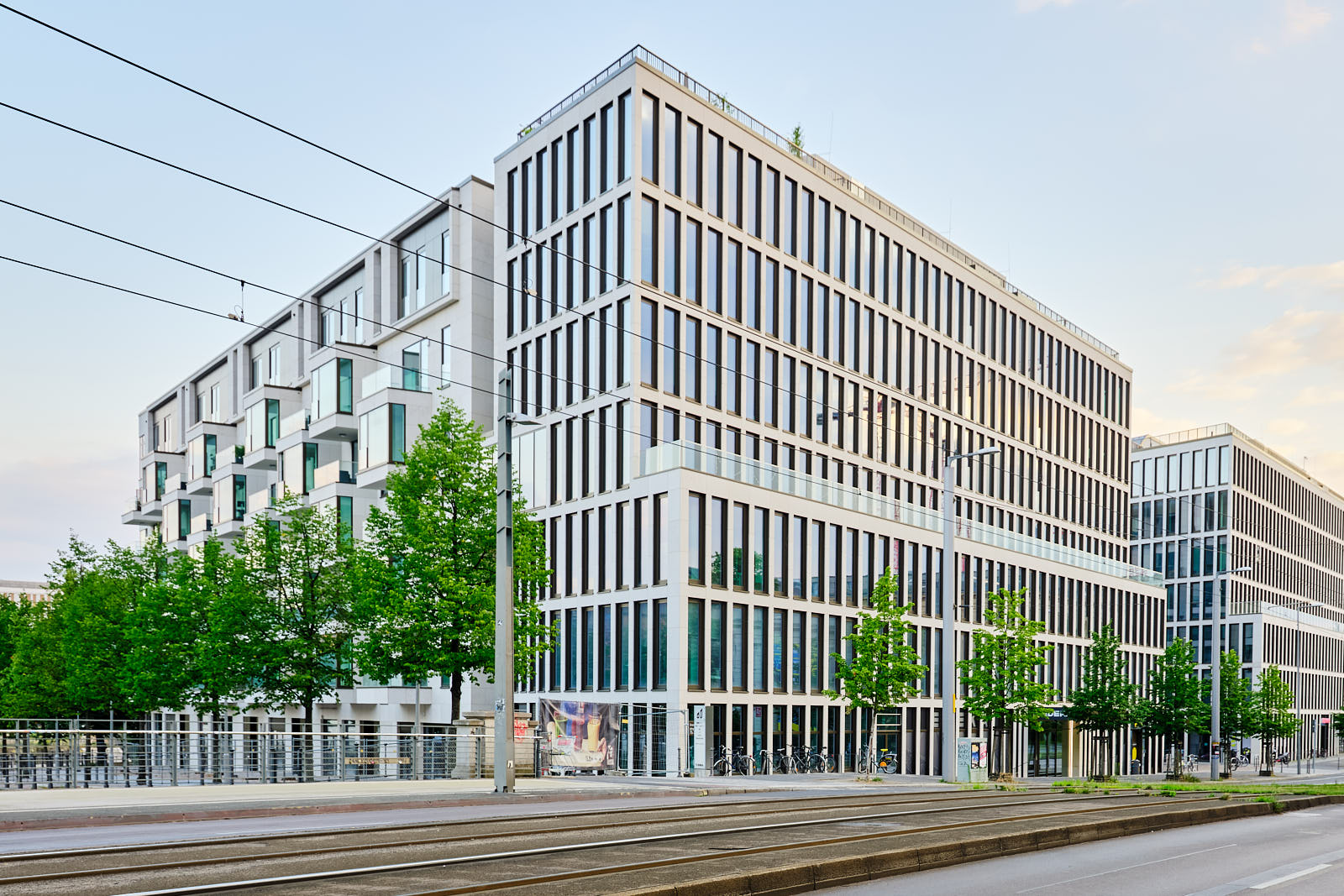 Modernes Bürogebäude in Berlin mit rhythmischer Fassadengliederung, großen Fensterflächen und Straßenbahntrasse im Vordergrund