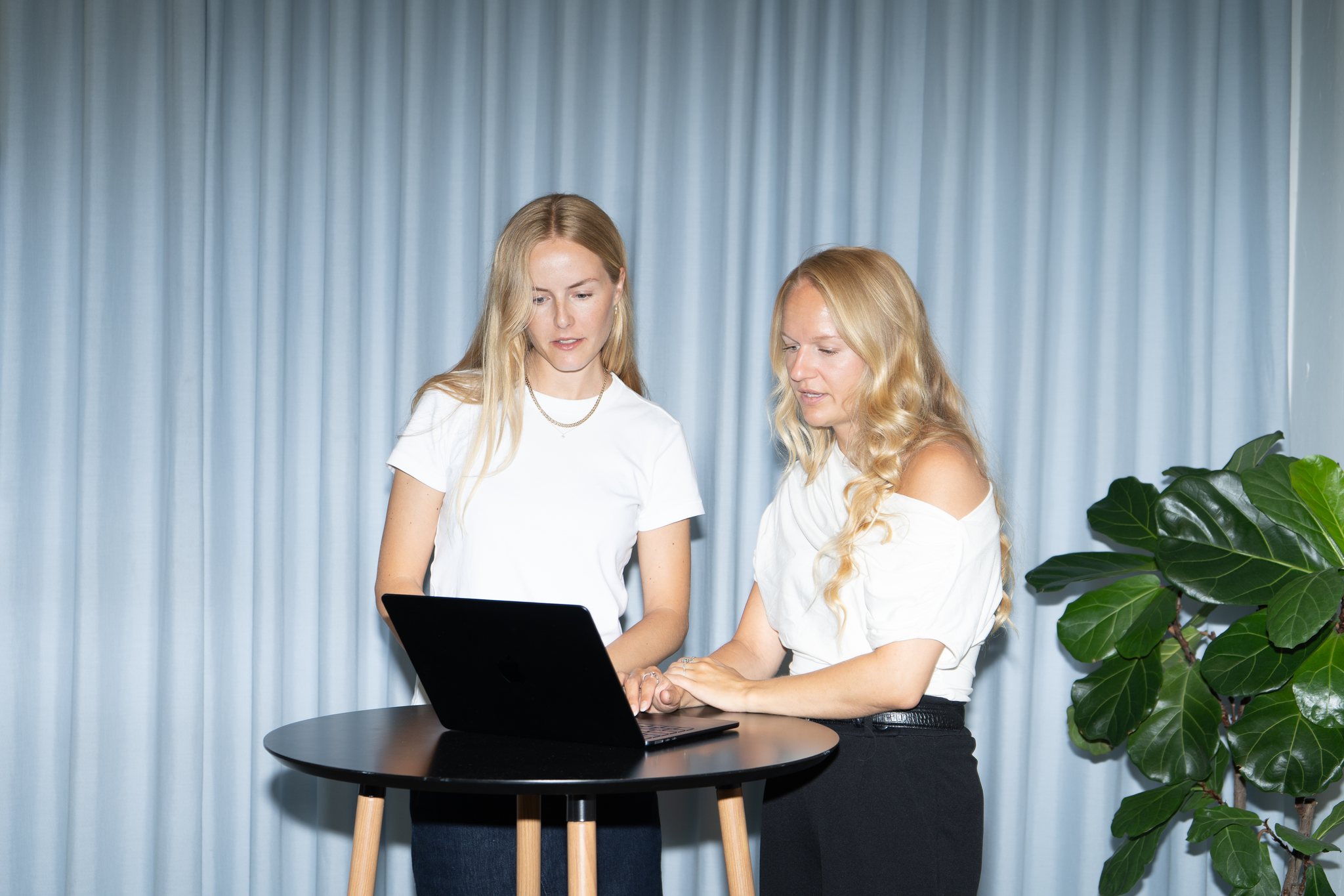 Julie Torp Rehn og Anna Labuhn Olesen ved et højt bord med en bærbar computer