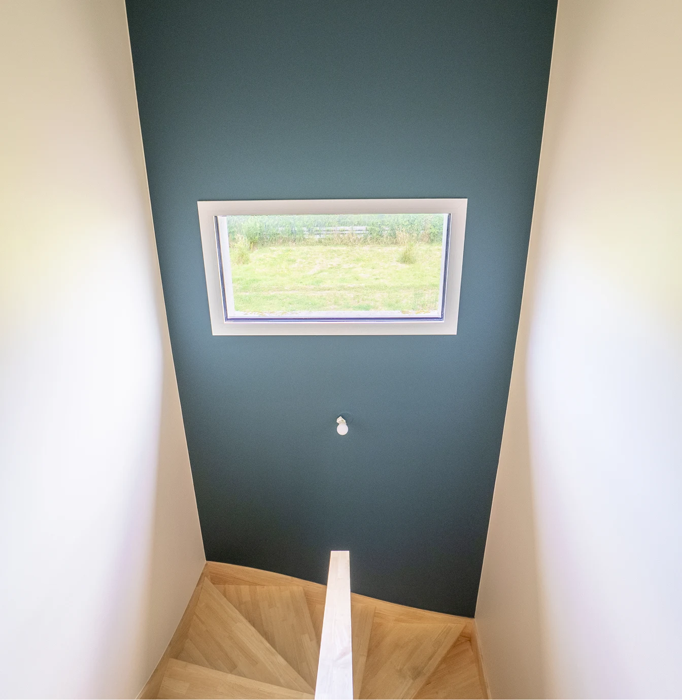 Cage d'escalier avec mur bleu canard et fenêtre de toit