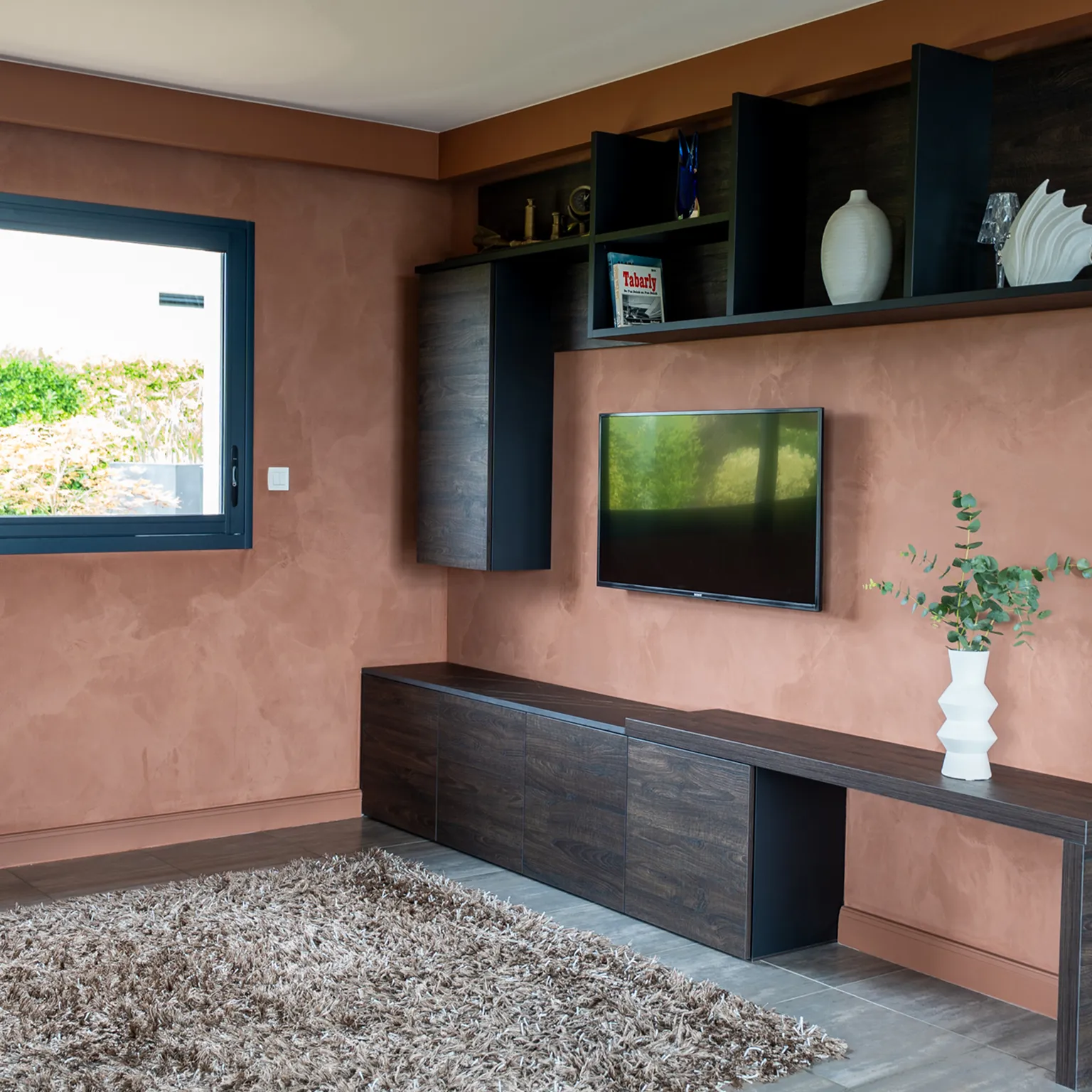Mur TV en chaux lissée terracotta avec meuble suspendu