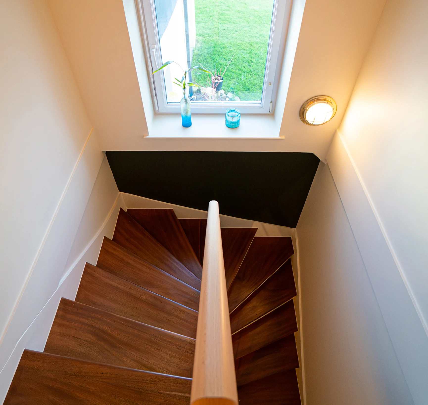 Escalier en bois vu d'en haut sous un velux, murs repeints à Saint-Pabu