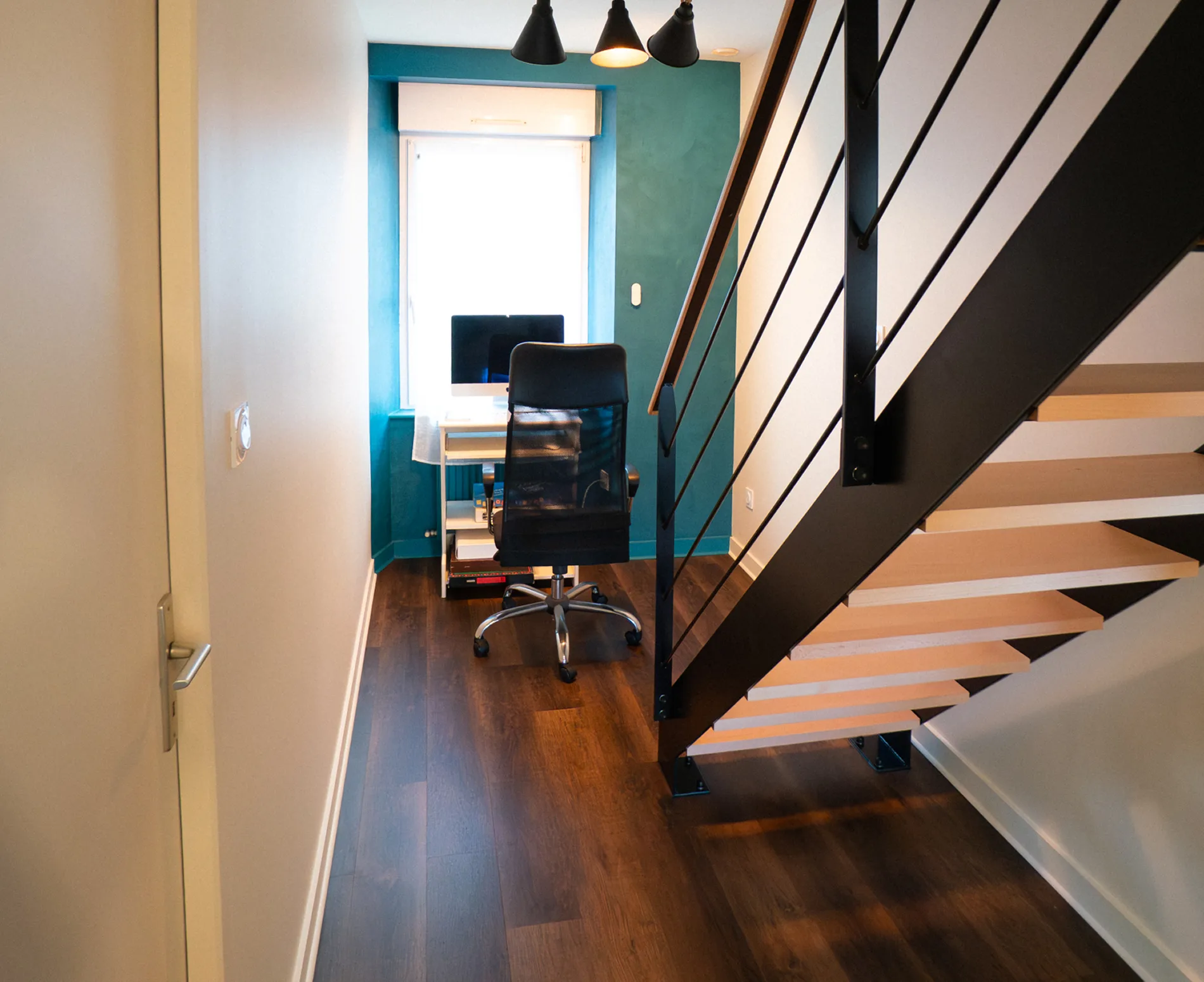 Palier rénové avec mur bleu canard en chaux et parquet à Saint-Pabu