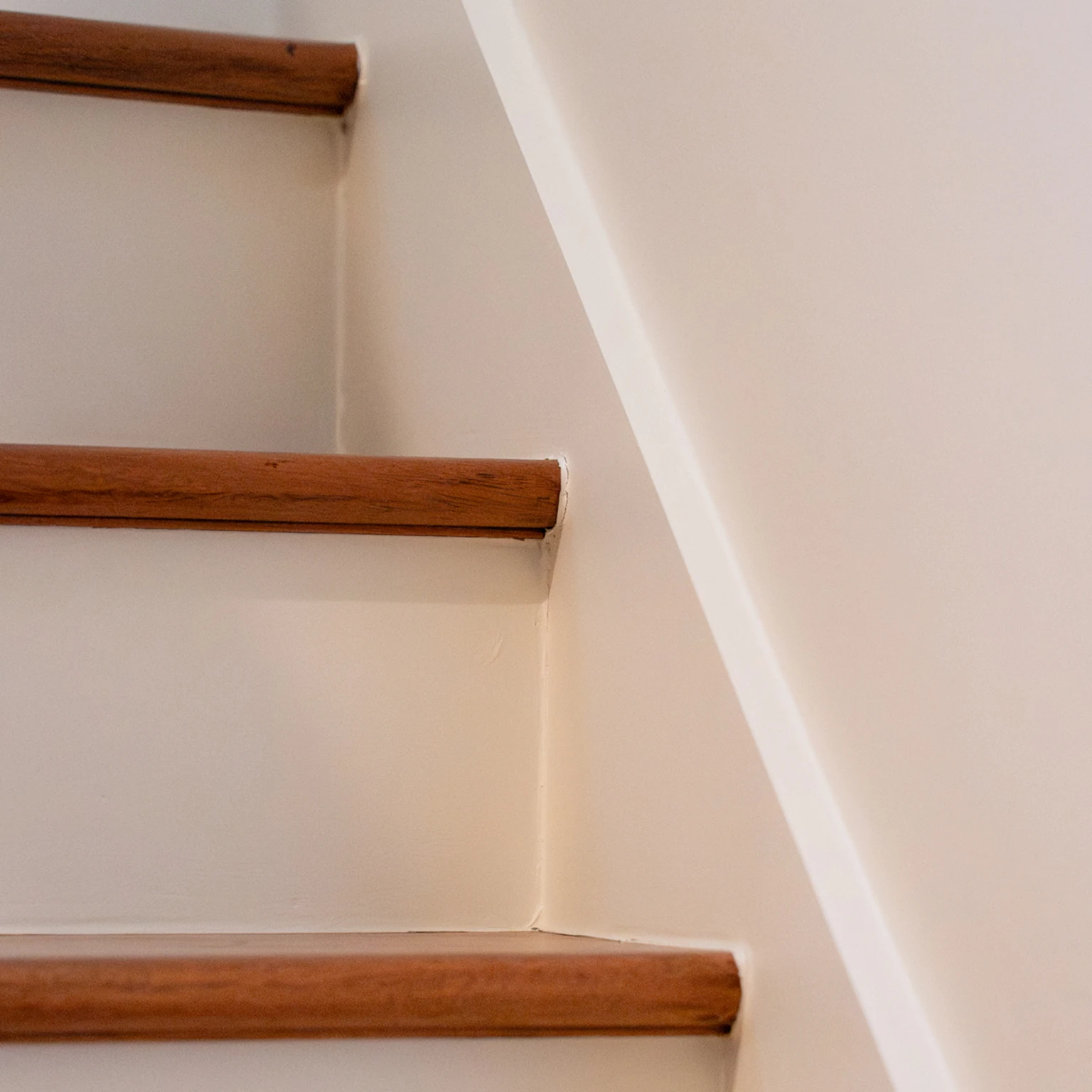 Détail des marches d'escalier et limon peint en blanc