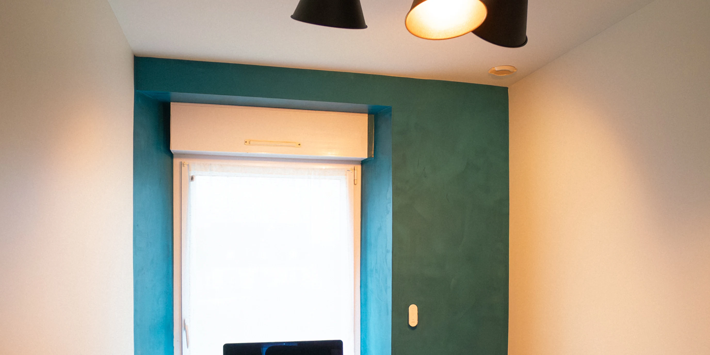 Bureau avec mur en chaux ferrée bleu canard autour de la fenêtre