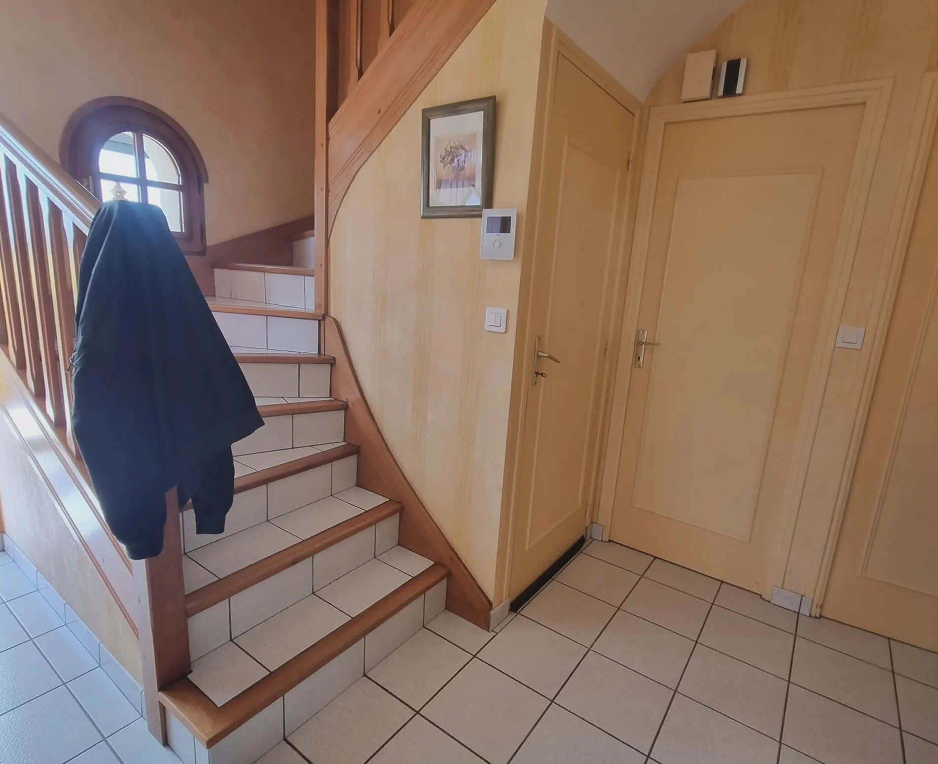 Entrée et escalier avant rénovation à Plouarzel, boiseries jaunies