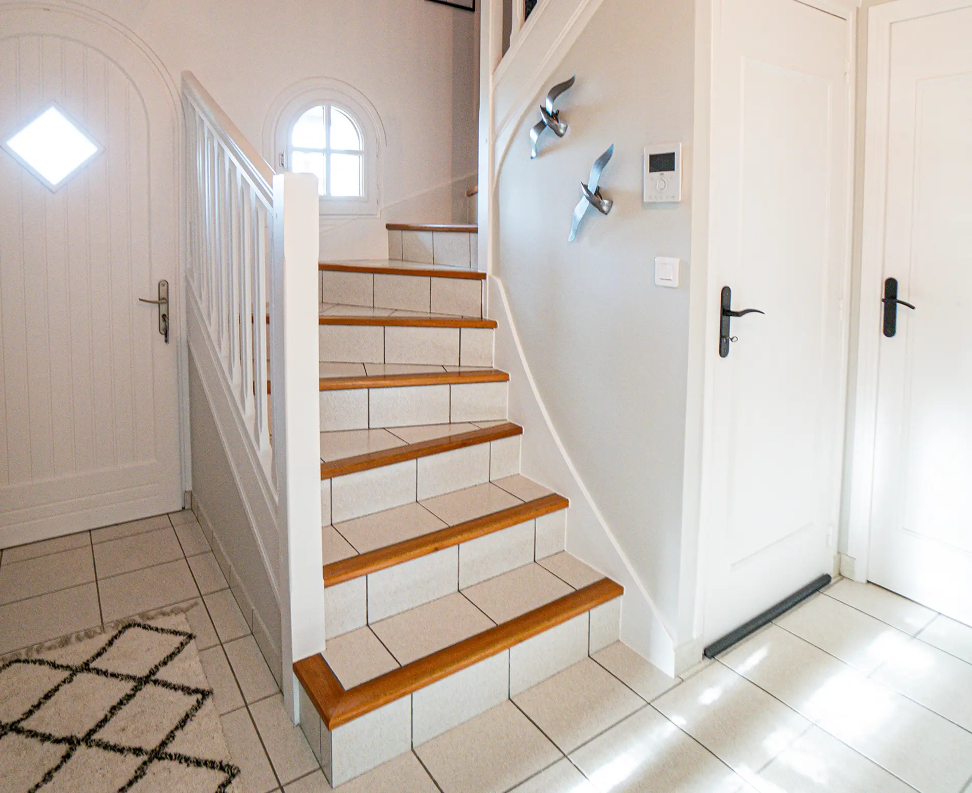 Entrée et escalier après rénovation à Plouarzel, peints en blanc