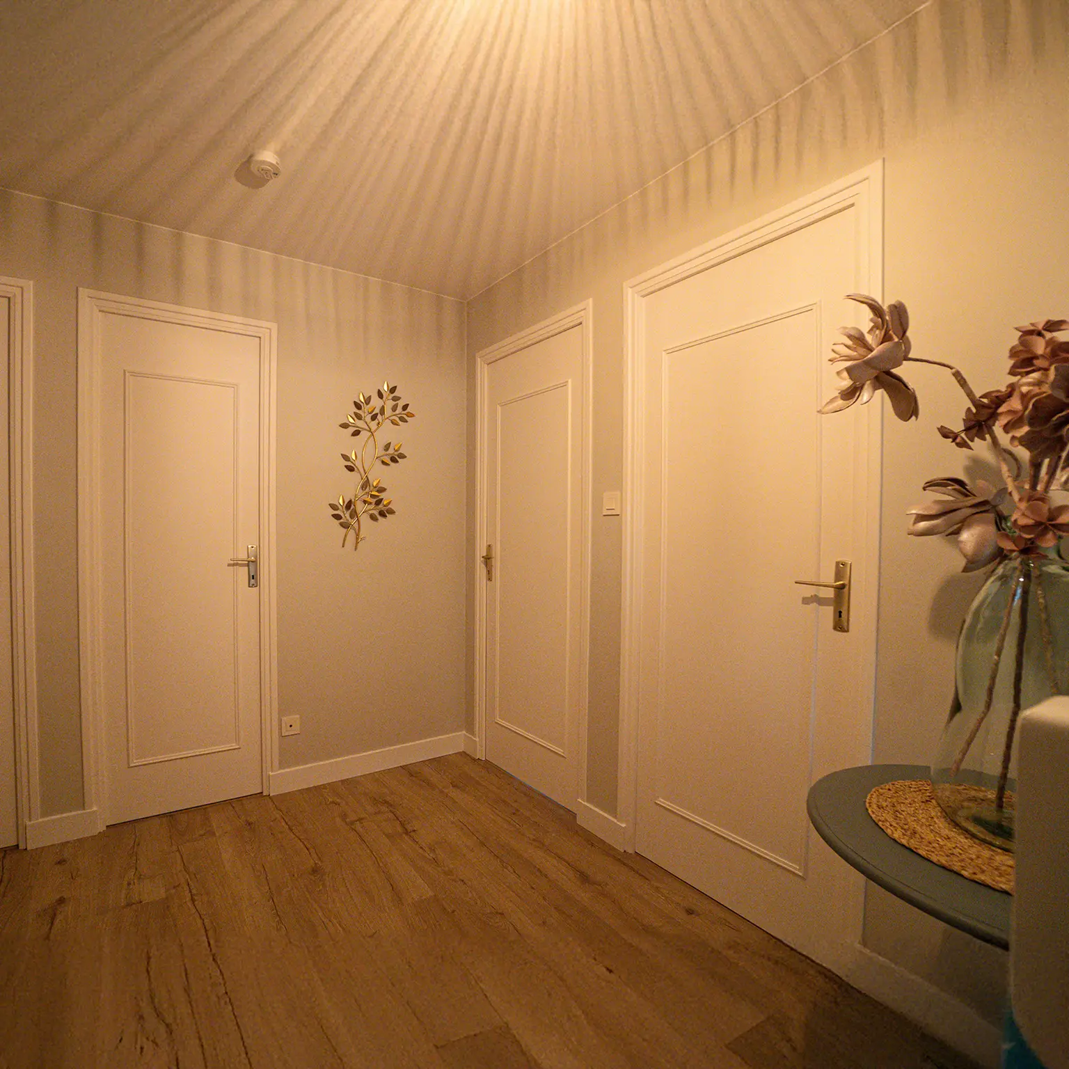 Palier de l'étage repeint avec portes blanches et parquet