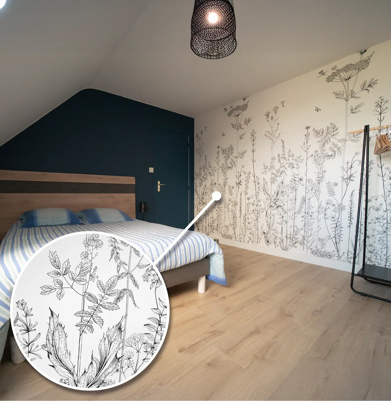 Chambre mansardée avec papier peint fleurs et mur bleu nuit