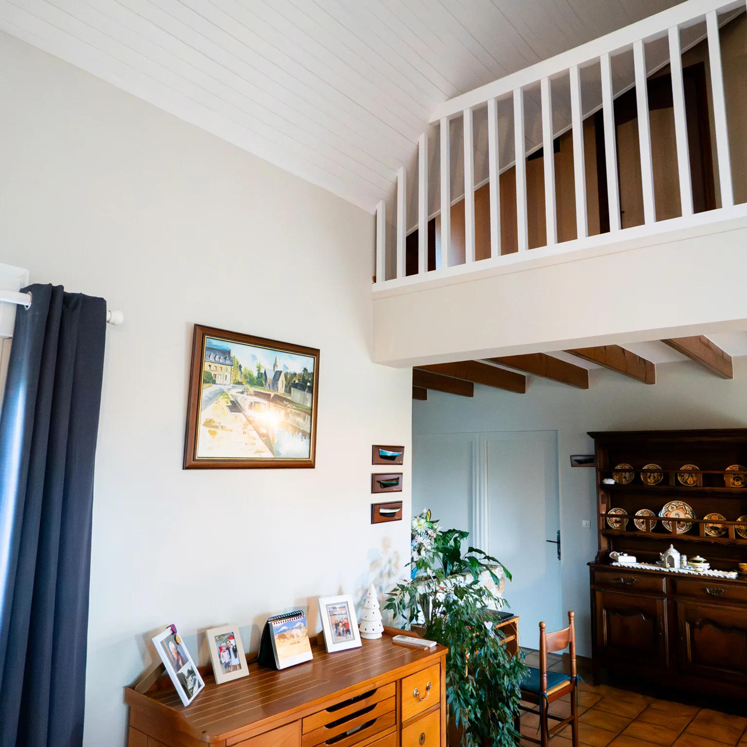 Mezzanine au garde-corps blanc au-dessus d'une salle à manger bleue