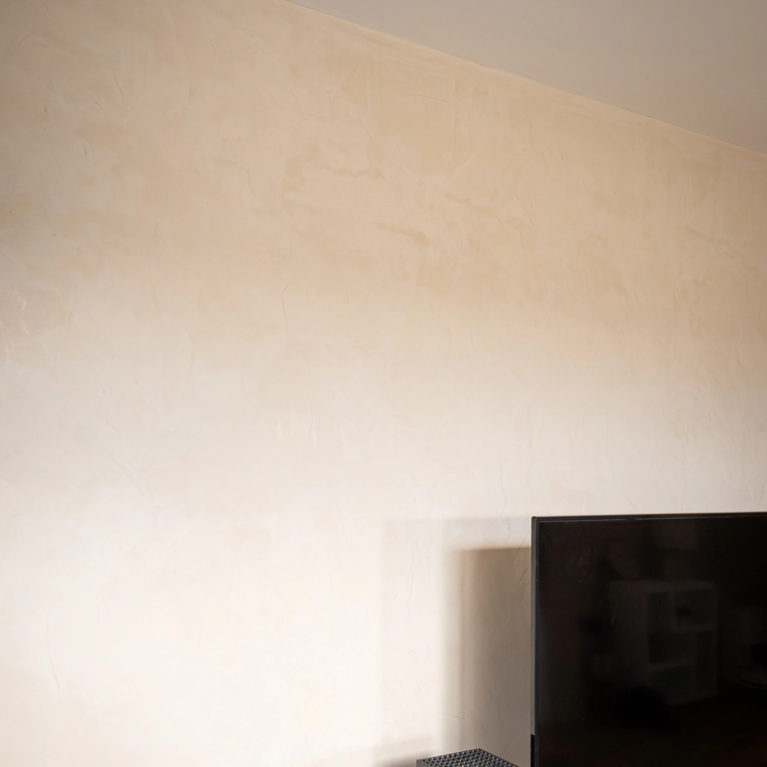 Enduit décoratif beige au mur du salon