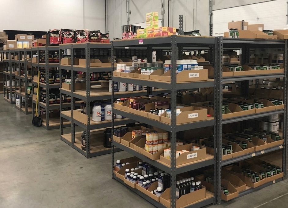 Climate-controlled supplement and vitamin storage at a 3PLCity fulfillment center, with bottles, protein powders, and capsule products organized in labeled bins on shelved racks for FIFO lot rotation.