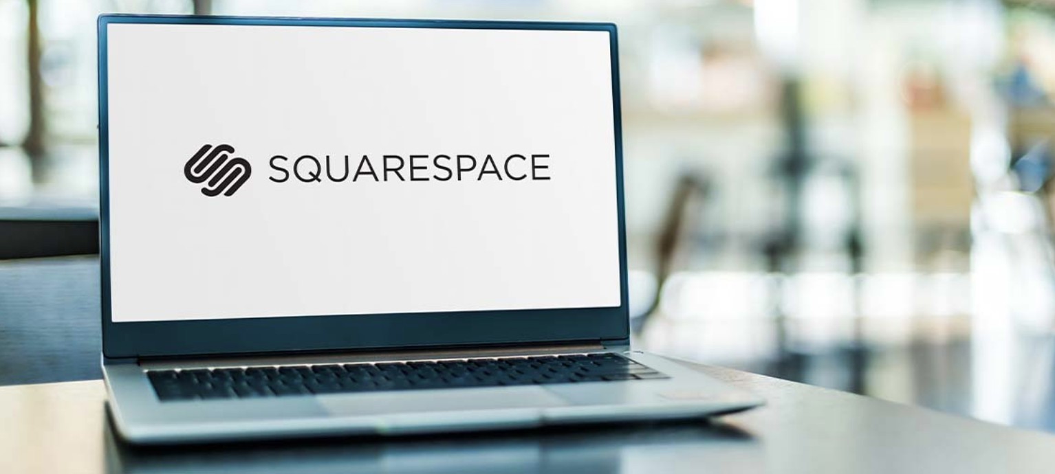 Squarespace website builder displayed on a laptop screen in a bright modern office