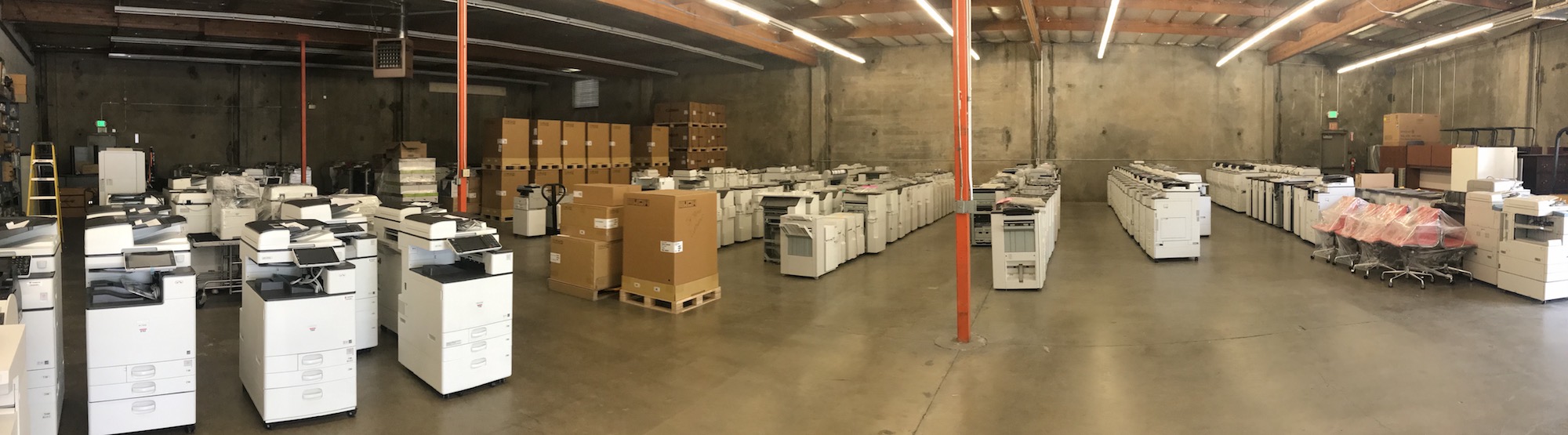 image of buckmaster's warehouse full of copiers and printers with packaged new machines