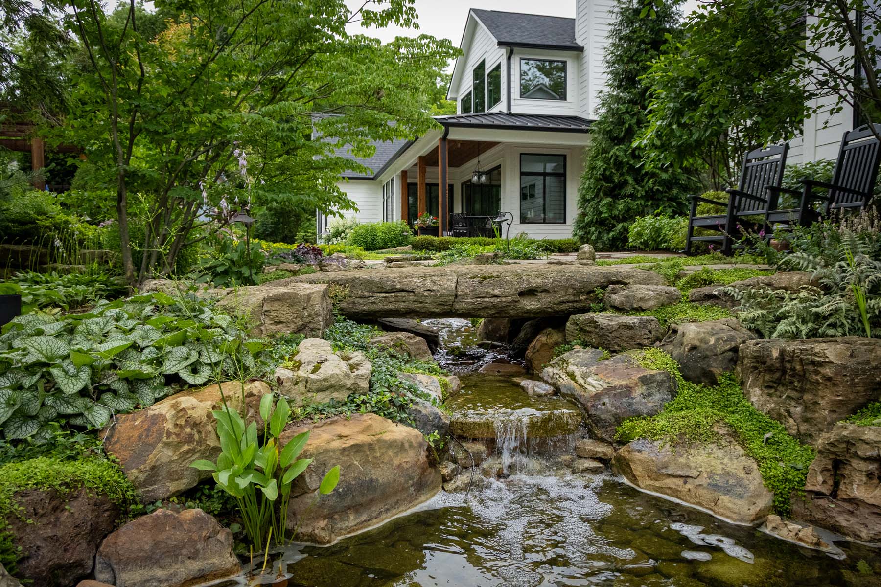 Stone bridge and waterfall landscape feature by Deming Property Solutions