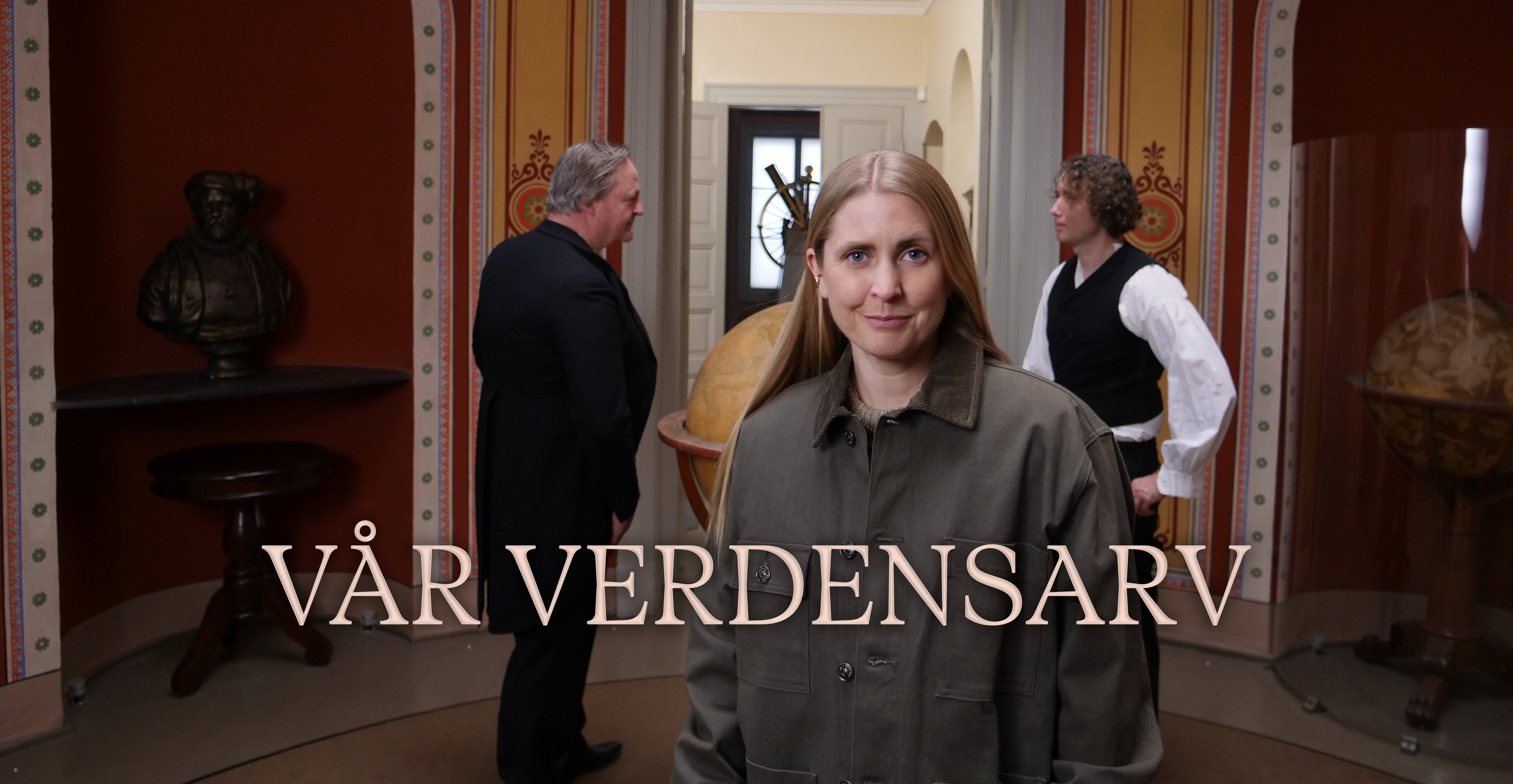En kvinnelig programleder står fremst i bildet med en grønn jakke på seg. Bak henne står to menn i klær fra 1800-tallet og diskuterer og man kan se en byste og to globuser ved siden av dem.