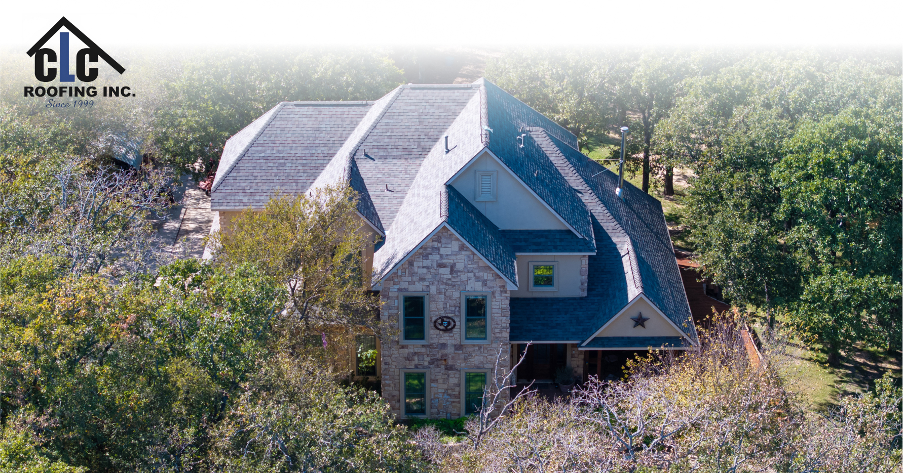 Side view of large stone home with multiple roof pitches and new shingles in Southlake TX