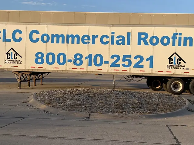CLC Roofing commercial roofing trailer with large blue lettering and phone number 800-810-2521, parked at a job site.