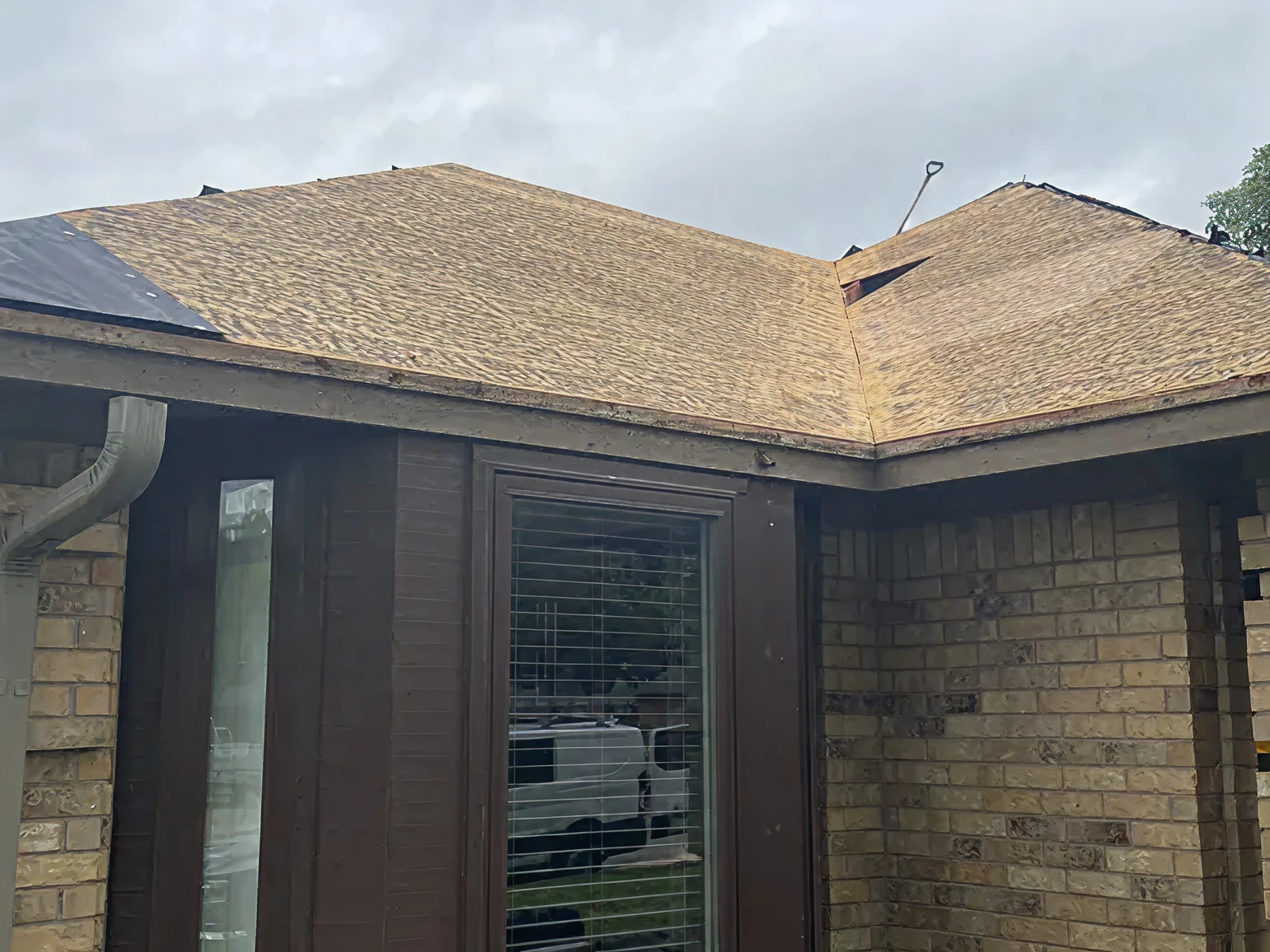 Close-up view of partially stripped roof showing hail damage before repair in Southlake TX
