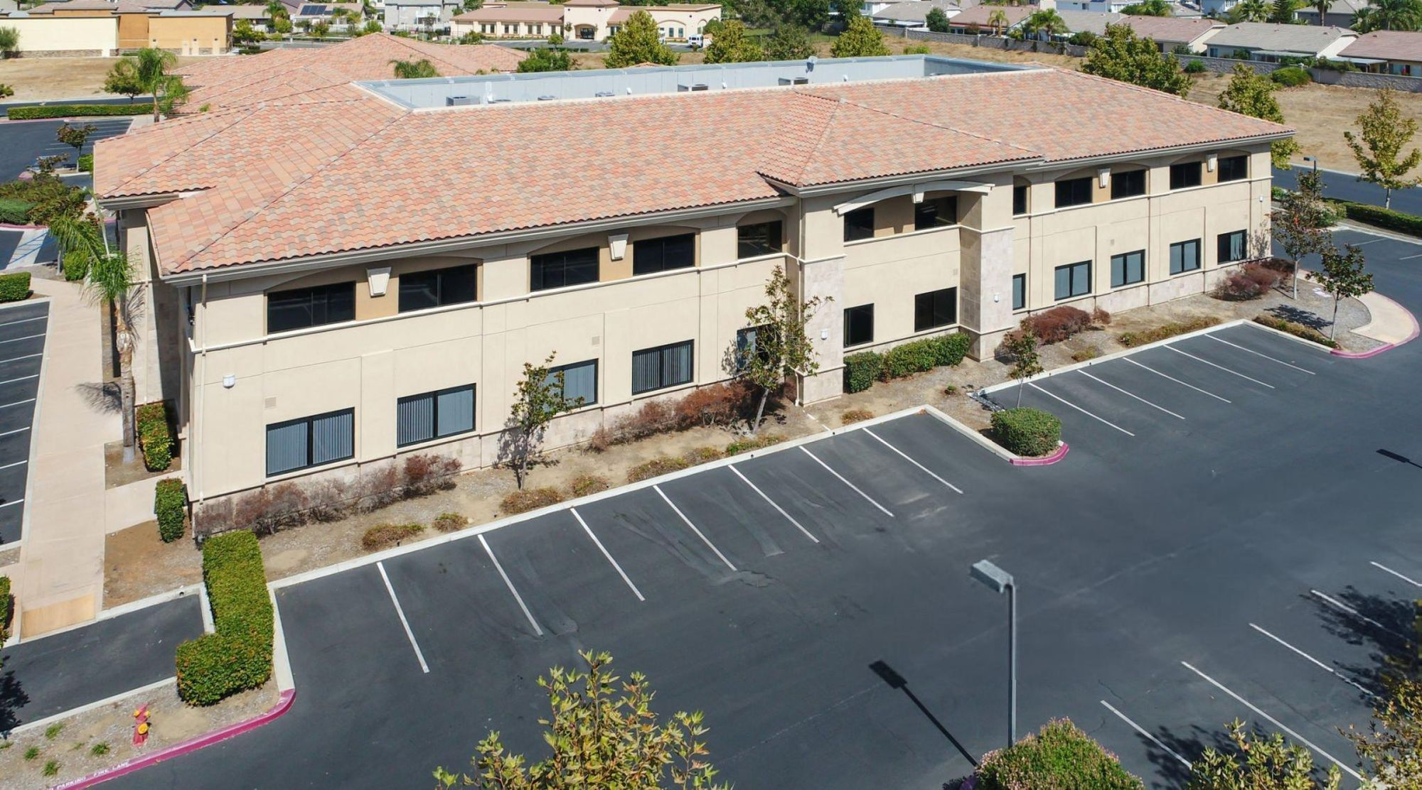 Aerial view of a commercial building with tile roofing installed by CLC Roofing, showcasing durability and professional craftsmanship.