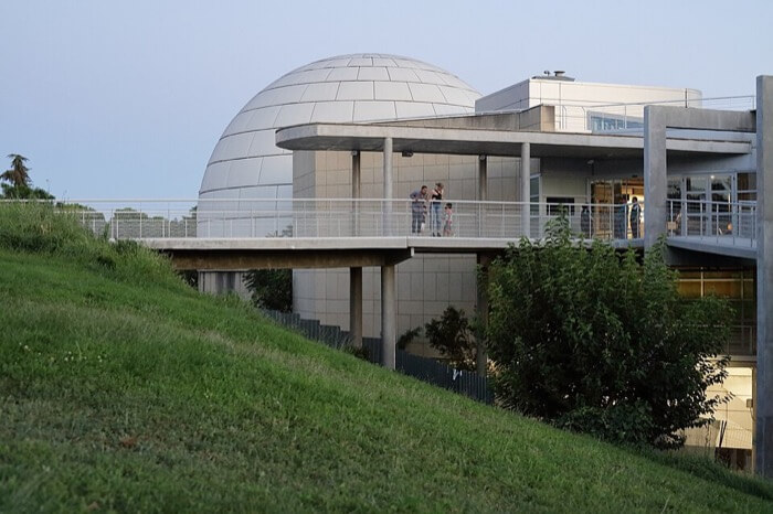 Exterior del Planetario de Madrid con su cúpula blanca y la colina verde que lo rodea