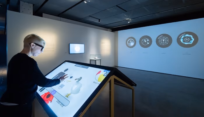 Visitor using an interactive touchscreen display at the Quantum Revolution exhibition at Espacio Fundación Telefónica in Madrid.