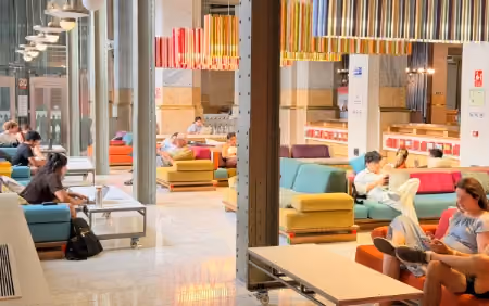 People reading and working at the Áreas Sociales at CentroCentro Cibeles
