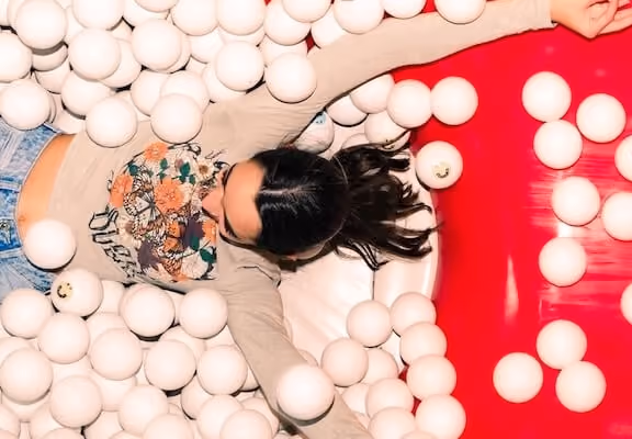 Girl having fun in the ball pit of Museum of Happiness