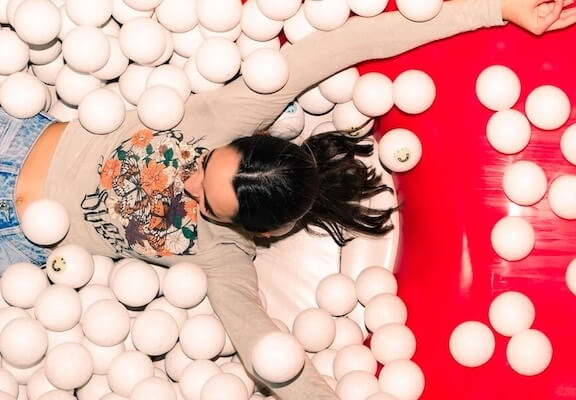 Girl having fun in the ball pit of Museum of Happiness