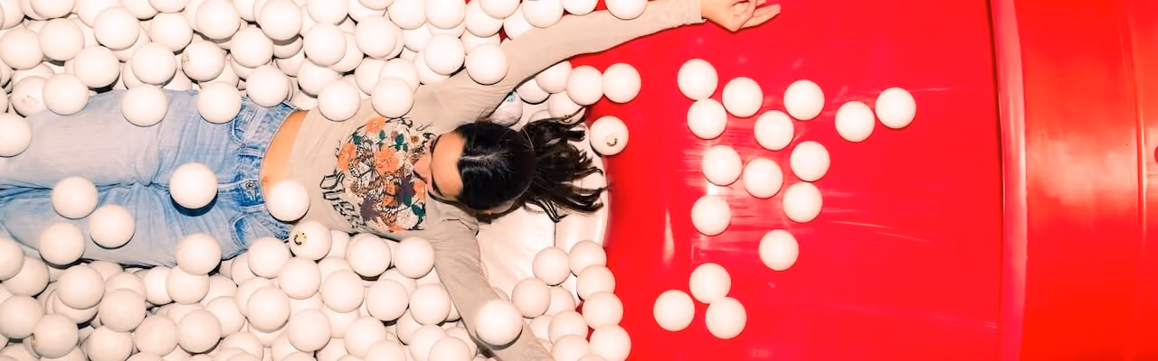 Girl having fun in the ball pit of Museum of Happiness