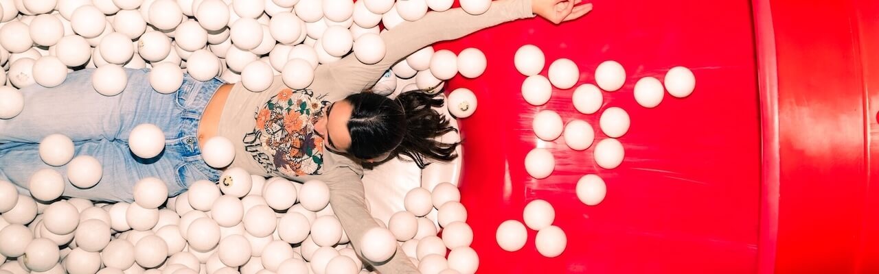 Girl having fun in the ball pit of Museum of Happiness