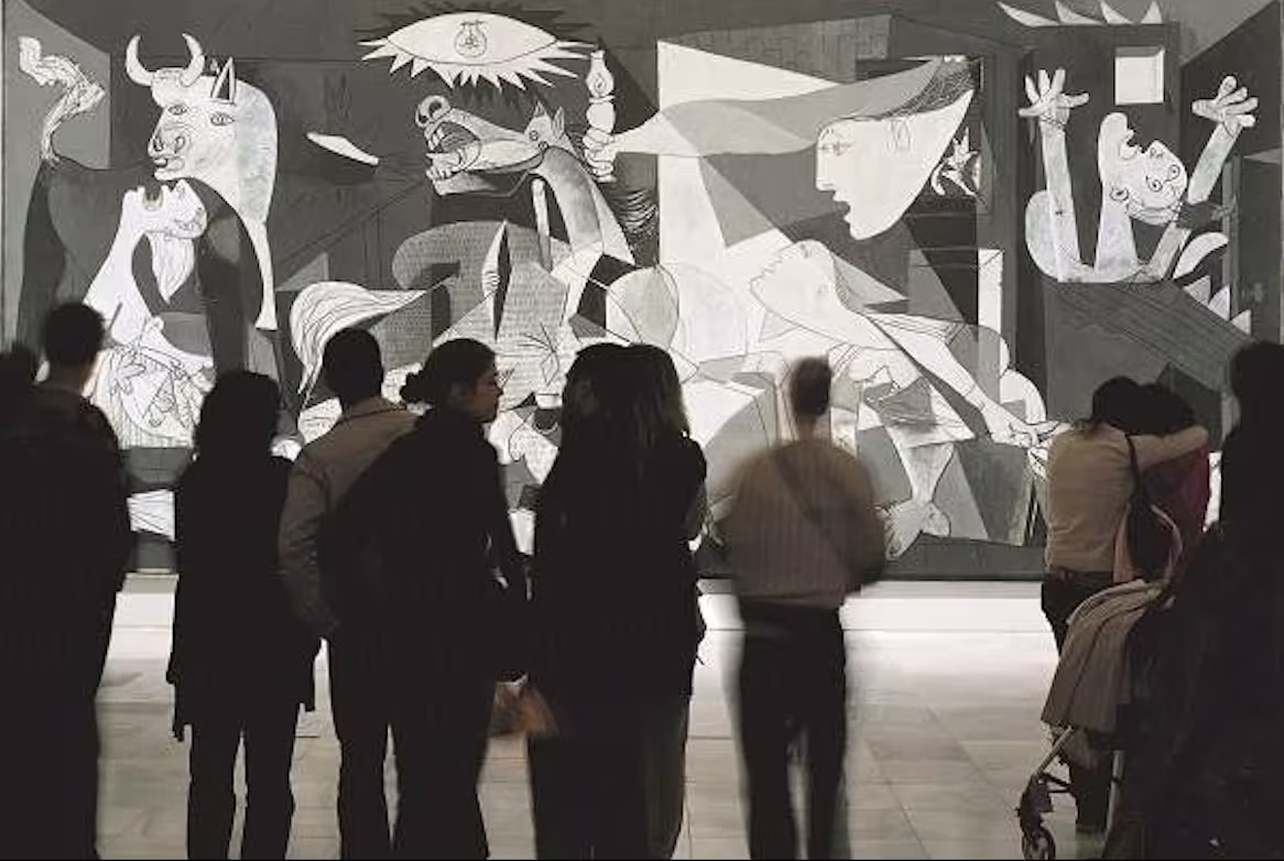 Visitors viewing Picasso's Guernica at Madrid's Reina Sofía Museum.