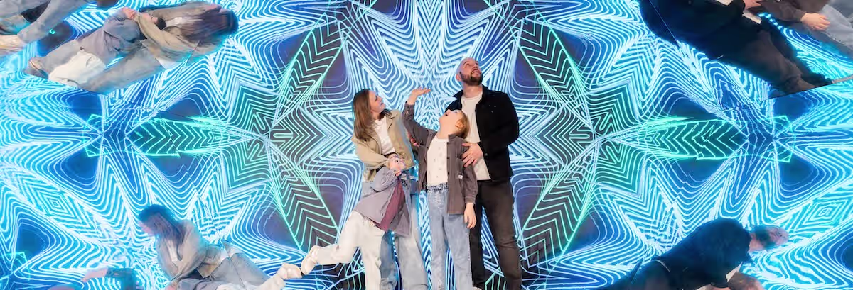 Family of 3 in a kaleidoscope-like room at Museum of Illusions Madrid
