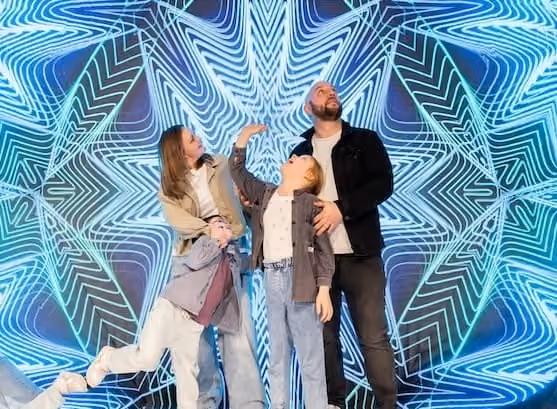 Family of 3 in a kaleidoscope-like room at Museum of Illusions Madrid