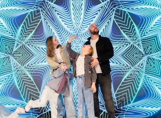 Family of 3 in a kaleidoscope-like room at Museum of Illusions Madrid
