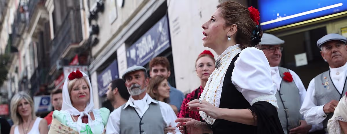 People wearing traditional chulapo and chulapa costumes during the San Lorenzo festival in Madrid's Lavapiés neighborhood