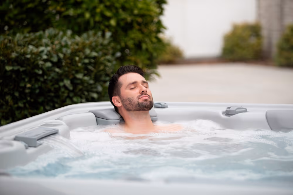 A man sitting and relaxing in an X series spa tub.