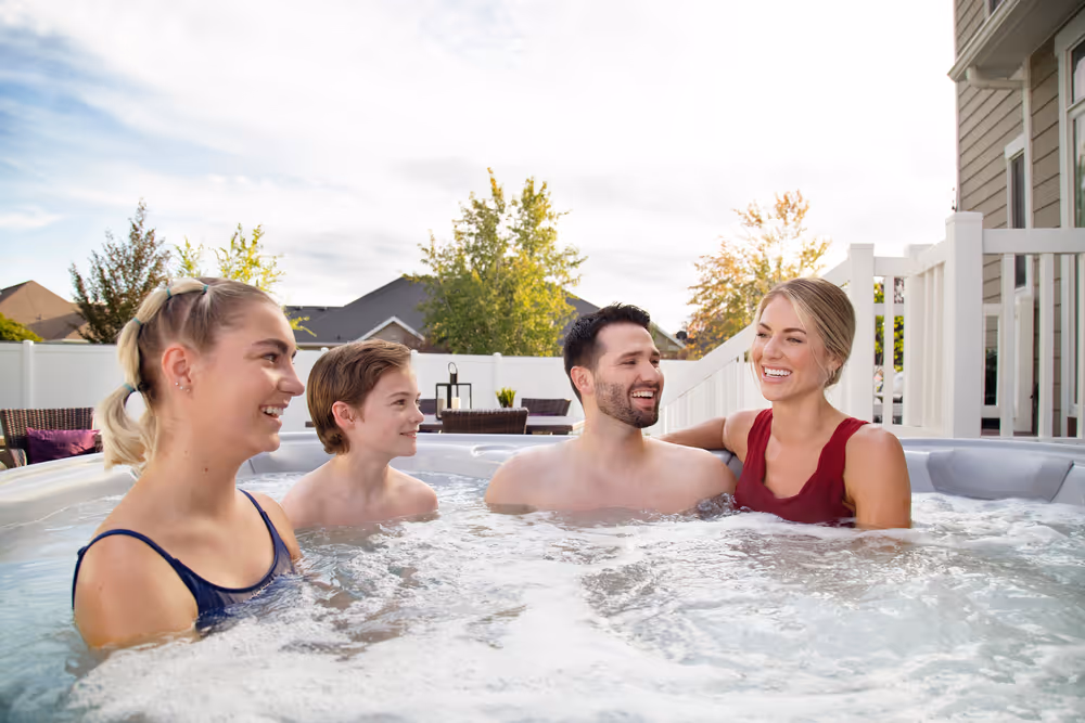 A family relaxing in an X Series spa outdoors.