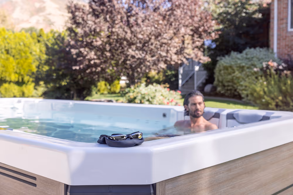 A man relaxing in the seating area of the S200 Swim Series spa.