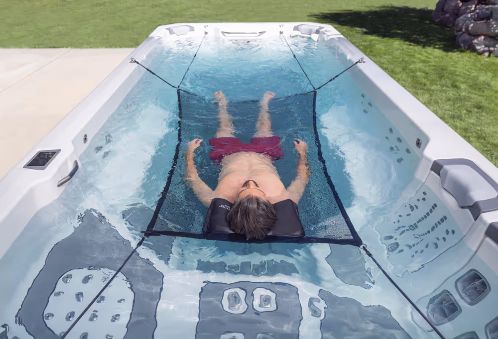 A person laying down on a supporting net in a Series spa.