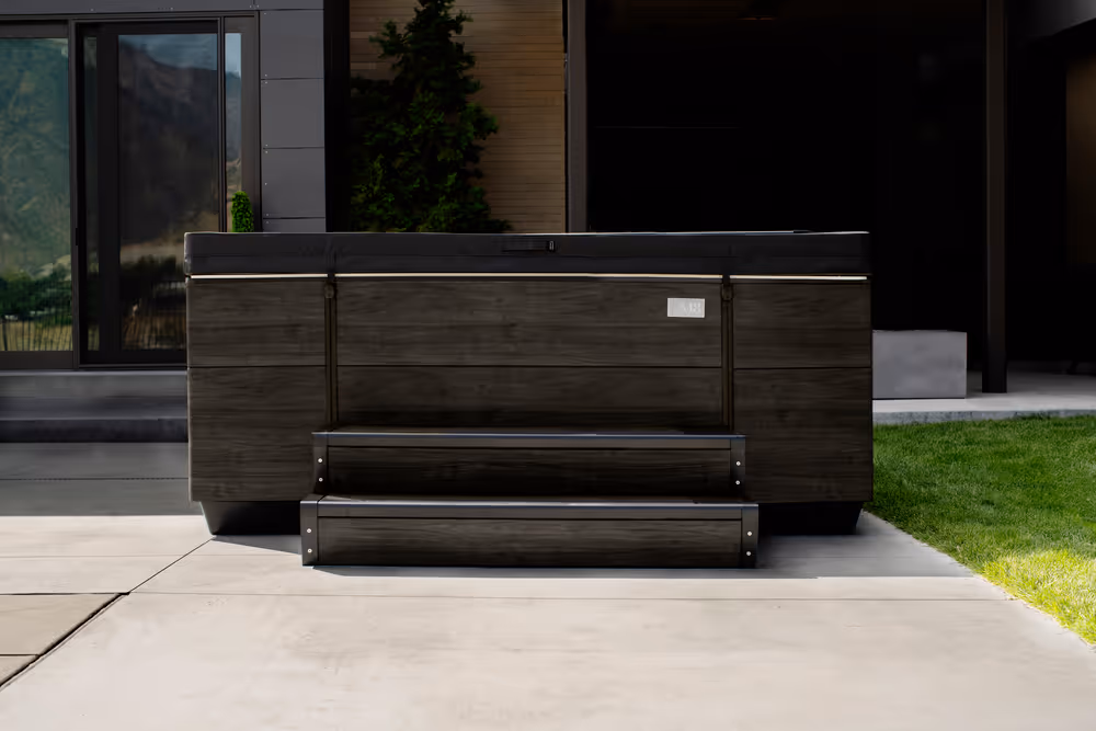 Front view of steps leading up to a dark-colored M series spa.