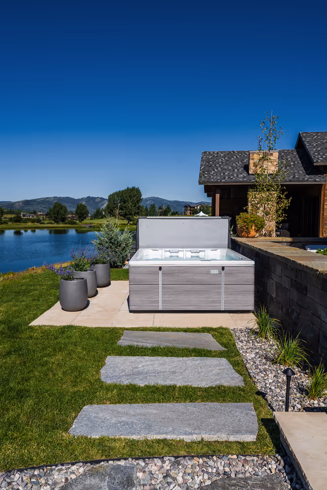 Front view of an M6 spa on a dedicated patio next to planters.