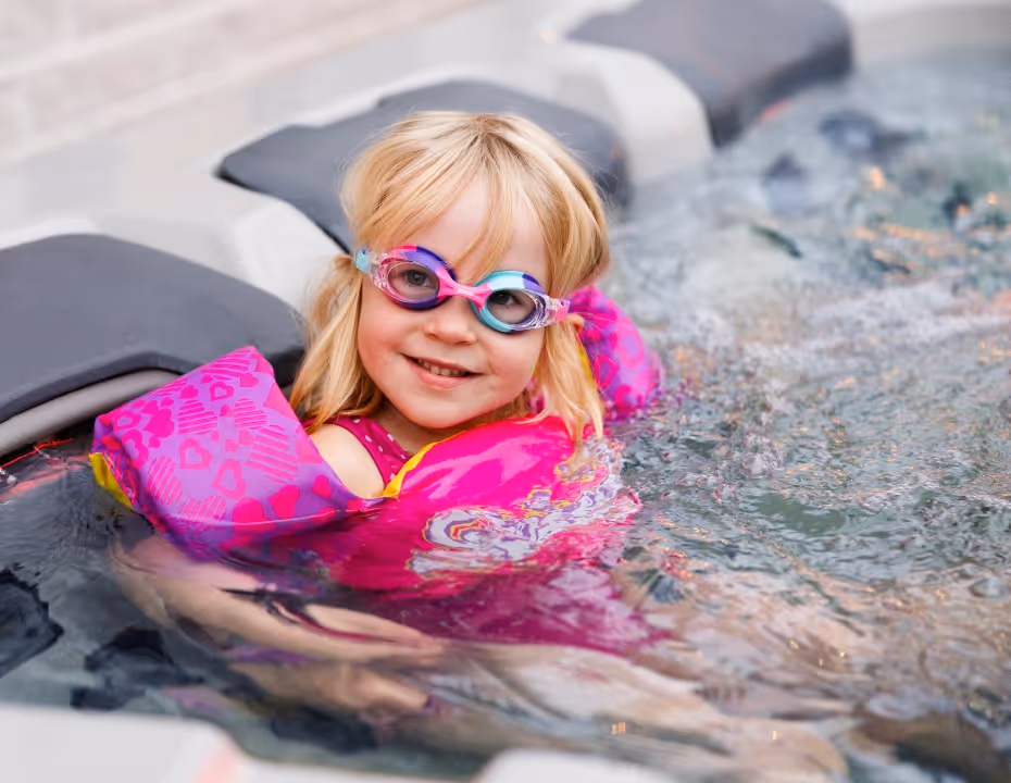 A child wearing floaties playing in an A Series spa.