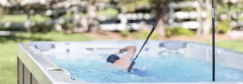 A person freestyle swims in a Swim series spa.